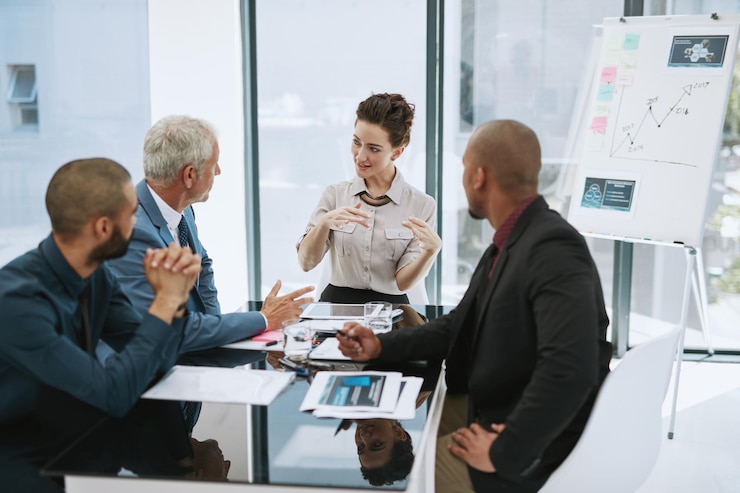 A team listening to a colleague in a bright meeting room