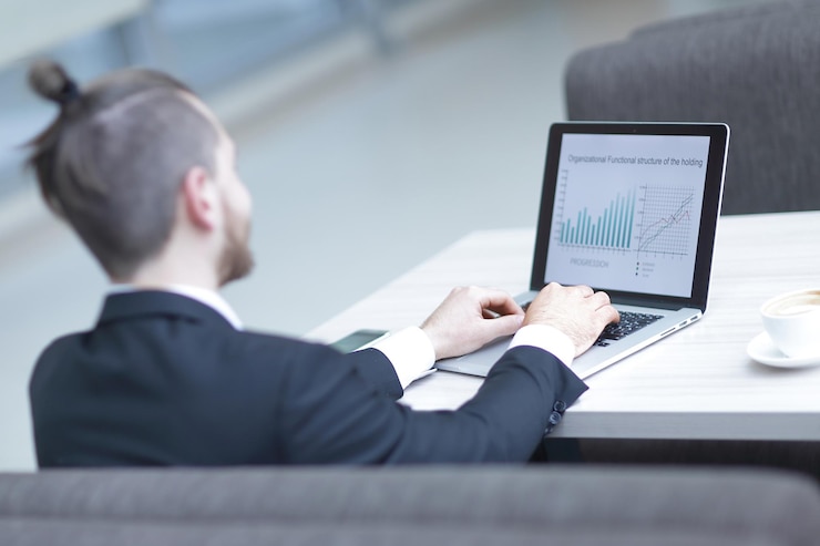 A man working through charts on a laptop
