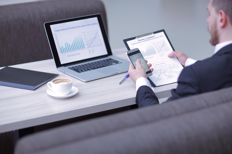 A laptop and a tablet showing charts on a desk