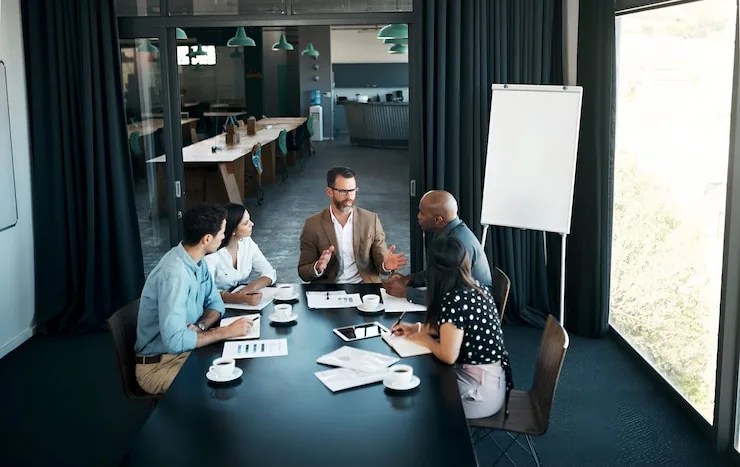 A meeting room seen from above with people at a long table